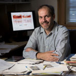 Jason West at his desk with papers in front of him