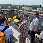 Group of people looking at air quality monitoring devices.